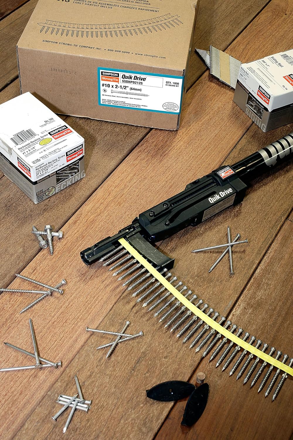 SIMpson Strong-Tie Quick Drive Pro 300S auto-feed screw driving tool with collated screws and packaging boxes on wooden floor