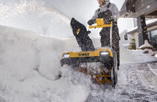 DeWalt 21-inch cordless snow blower with 60V FLEXVOLT system clearing heavy snow from driveway outdoors