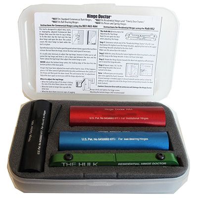 Hinge Doctor adjustment kit with red, blue, and green cylinders for commercial and residential hinge repair in gray plastic case