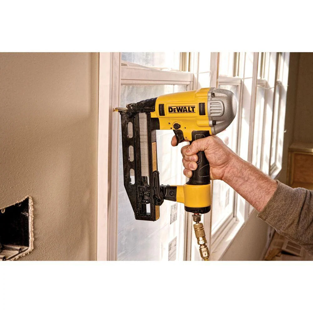 DEWALT 16 gauge finish nailer DWFP71917 held in hand, driving nails into interior molding near window frame