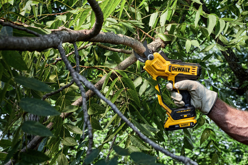 Cordless 20V pruning shear cutting a tree branch with ergonomic handle and battery pack in outdoor garden setting