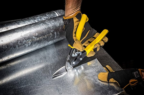 Cisaille et pince découpant une feuille de métal