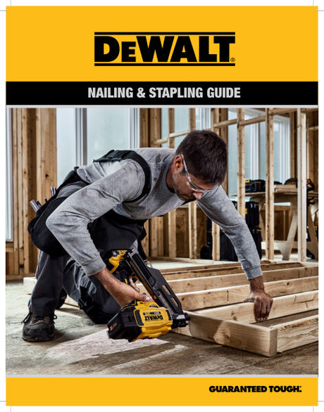 Worker using a yellow and black DEWALT pneumatic framing nailer on wooden beams inside construction site