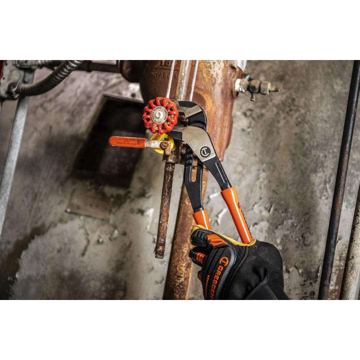 8'' adjustable Crescent RTZ28 pliers with ergonomic orange handles gripping rusty valve pipe in industrial setting