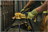 DeWalt 20V MAX XR pipe cutter with chain grip cutting 1-1/4 inch copper pipe, held by a worker with gloves