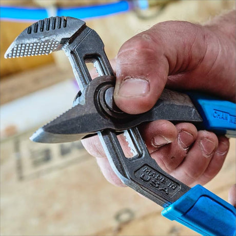Close-up of Channellock GS-3 adjustable groove joint pliers with blue grips held in hand on workshop background