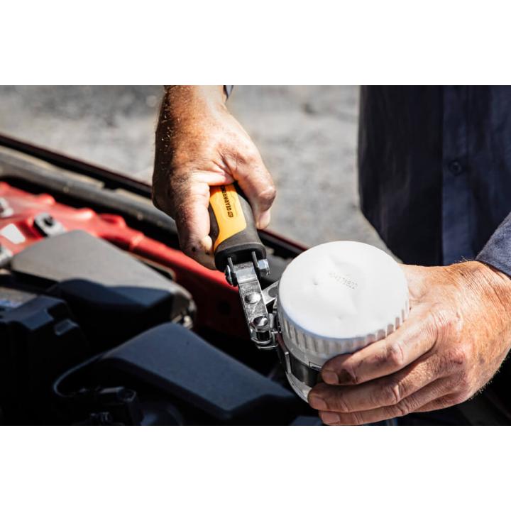 Large Gearwrench 3943 oil filter wrench with ergonomic yellow handle used on white car oil filter cap