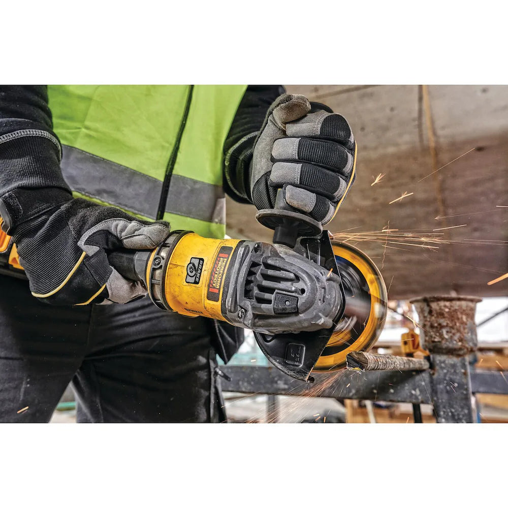 Cordless 60V FLEXVOLT angle grinder with side handle, cutting metal pipe, sparks flying in industrial setting