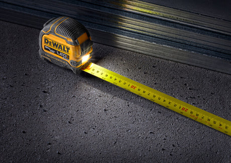 DeWalt ToughSeries measuring tape with integrated LED light and durable case, measuring extended on rough surface