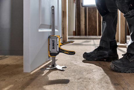 Compact construction jack with DEWALT TOUGHSERIES label, adjustable base, and ergonomic yellow handle on concrete floor