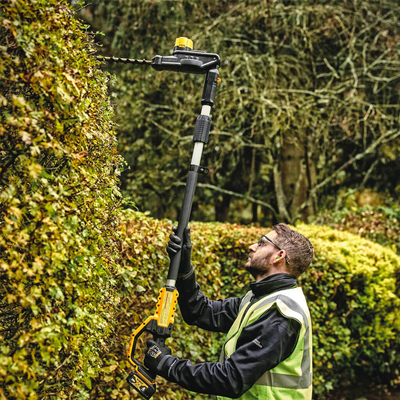 Telescopic pole hedge trimmer with 22-inch hardened steel blade and high-efficiency motor for landscape maintenance.