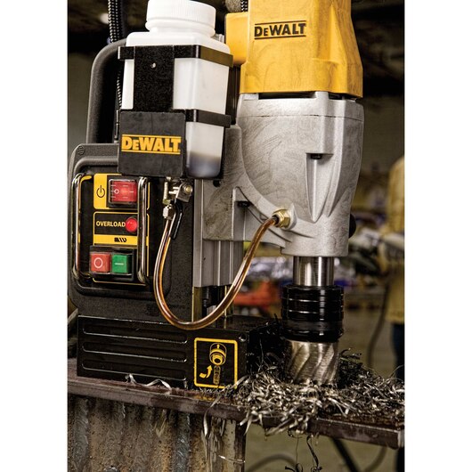 DeWalt 2" magnetic drill press with 10A motor, dual-speed settings, overload protection, and coolant system in use drilling steel